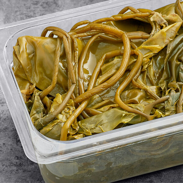 A plastic container with green seaweed.