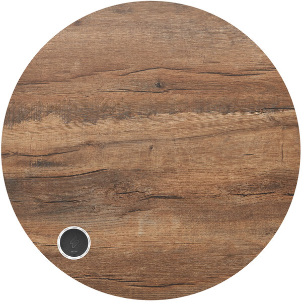 A circular wood BFM Seating table top with a silver circle containing a black lightning bolt.