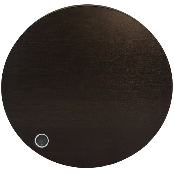 A round black BFM Seating Midtown table with a round black wireless charger on it.