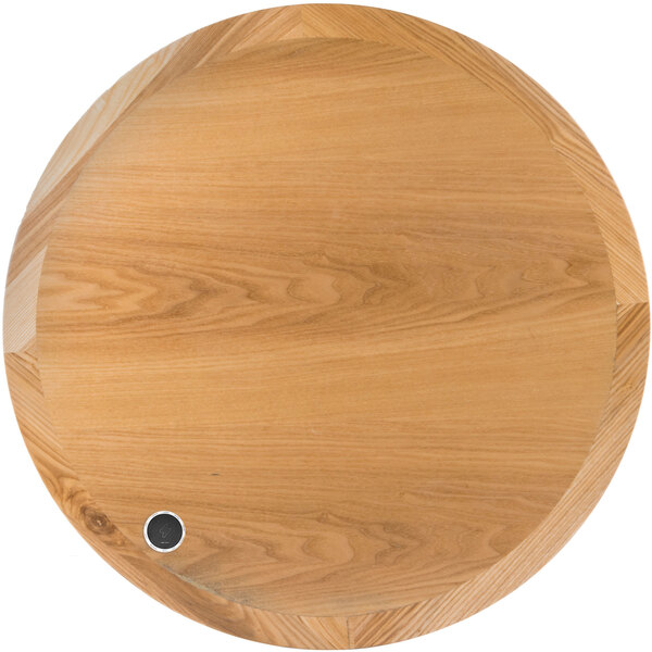 A BFM Seating round natural ash veneer wood table top with a metal circle in the center.