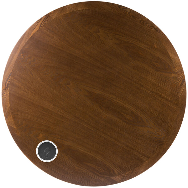 A BFM Seating round wooden table top with a silver circle on it.