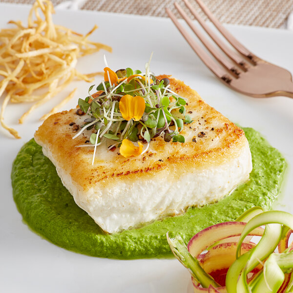 A white plate with a piece of Wulf's Skin-On Halibut topped with sprouts.