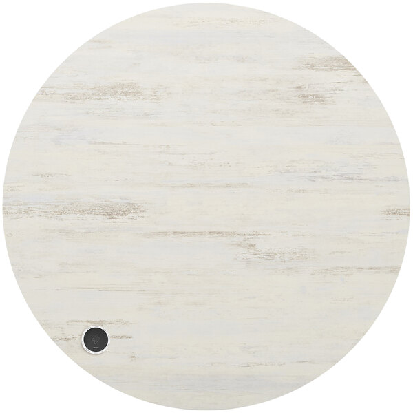 A white round BFM Seating melamine table top with a black circle for a wireless charger.