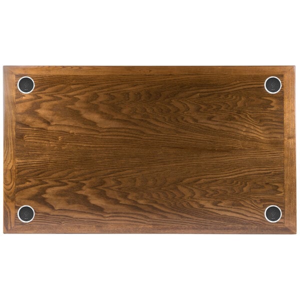 A BFM Seating rectangular wood table top with four round metal circles in the surface.