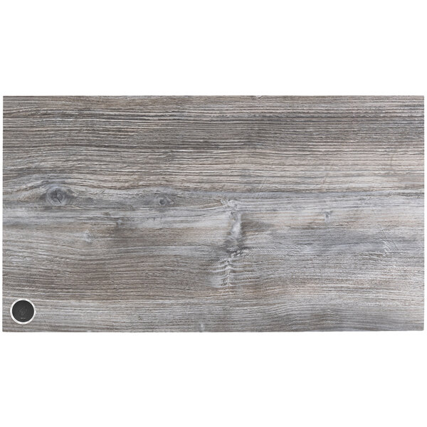A Driftwood BFM Seating rectangular table top with a hole in the middle of the wood surface.