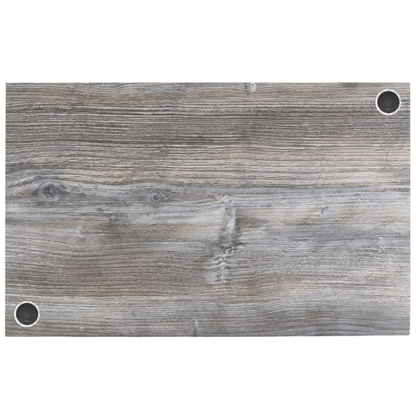 A BFM Seating Midtown rectangular tabletop in driftwood with wireless chargers.