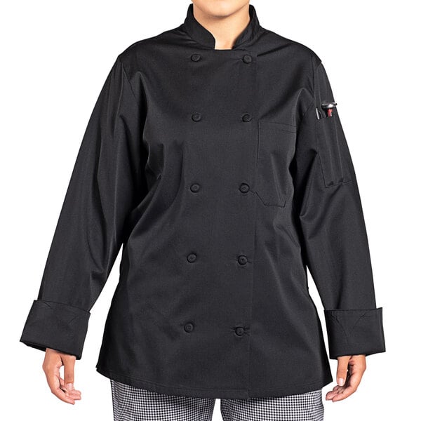 A woman wearing a black Uncommon Chef Tempest Pro Vent long sleeve chef coat.