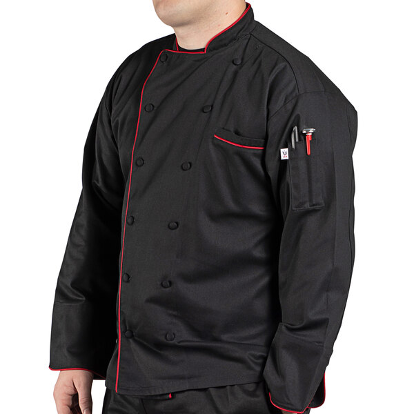 A man wearing a black Uncommon Chef long sleeve chef coat with red trims.
