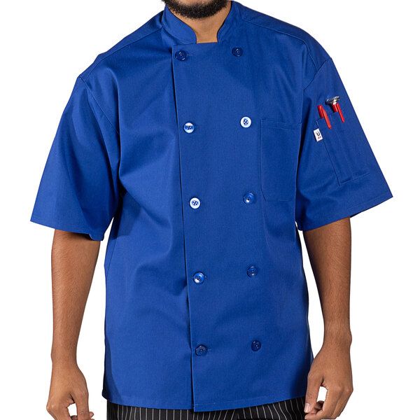 A man wearing a royal blue Uncommon Chef short sleeve chef coat.