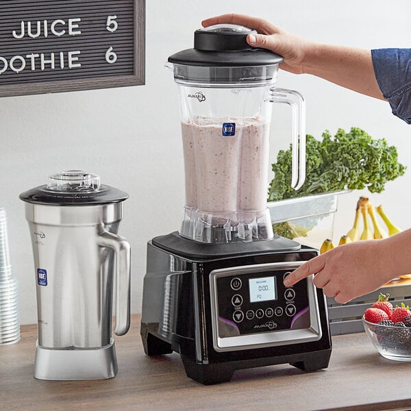 A woman using a black and silver AvaMix commercial blender to make a smoothie.