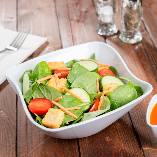 A bowl of salad with vegetables in a GET San Michele white melamine bowl.