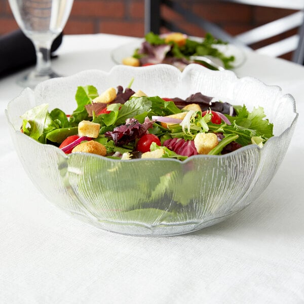A table set with a salad in an Arcoroc glass bowl.