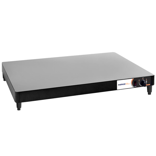 A rectangular black and white Nemco heated shelf warmer.