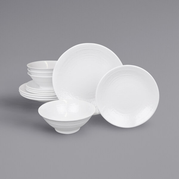 A stack of white plates and bowls with a white background.