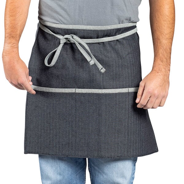 A man wearing a denim waist apron with black webbing.