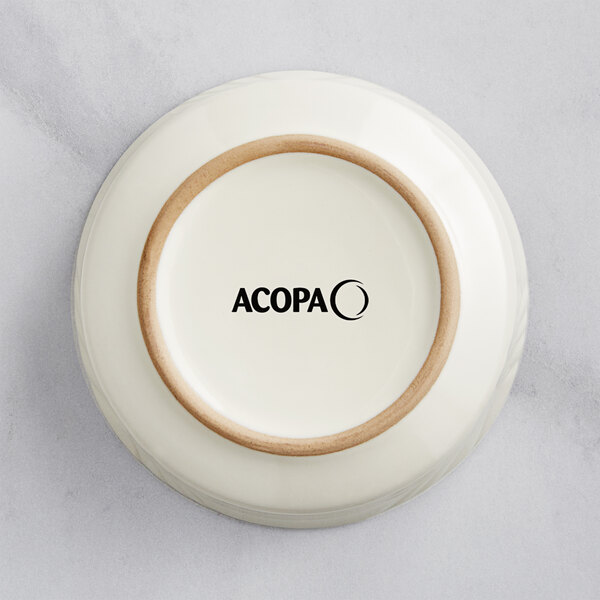An ivory stoneware bowl with the word Acopa embossed on it.