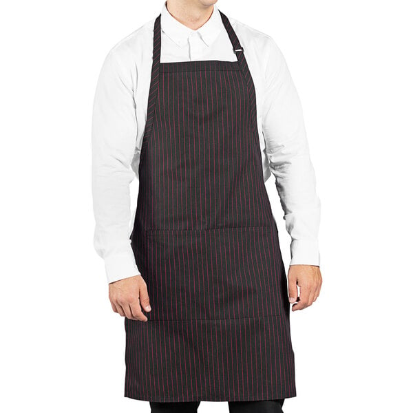 A man wearing a black and red pinstripe Uncommon Chef butcher apron.