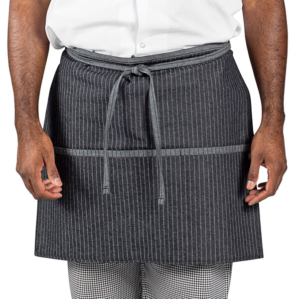 A man wearing a black and white pinstripe denim waist apron.