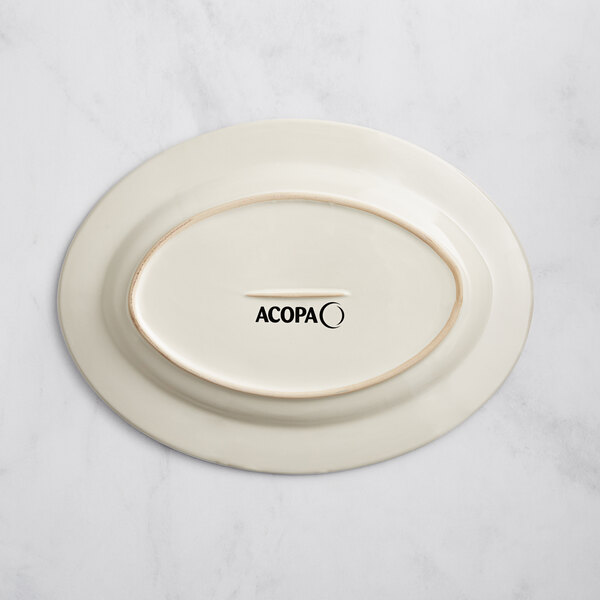 An ivory oval stoneware platter with an embossed rim and black text reading "Acopa" on it.