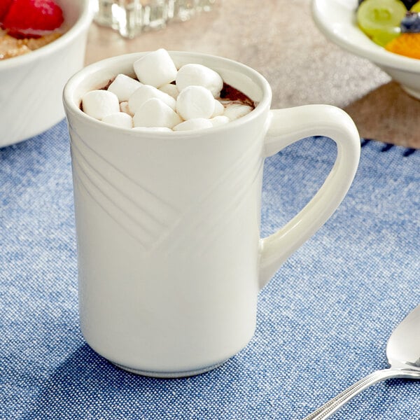 An ivory Acopa stoneware mug filled with hot chocolate and marshmallows.