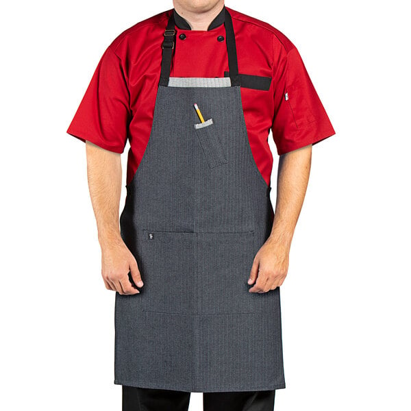 A man in a black denim chef apron with black webbing over a red shirt.