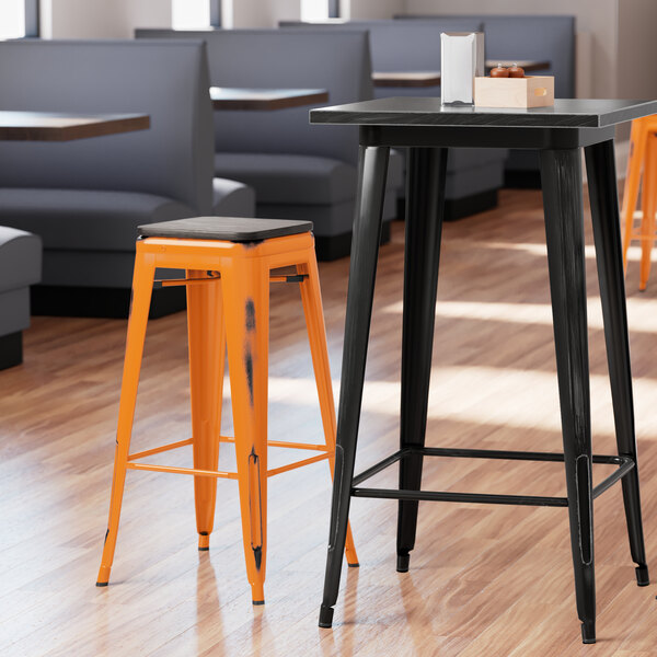 Lancaster Table & Seating Alloy Series Distressed Orange Stackable Metal Indoor Industrial Barstool with Black Wood Seat