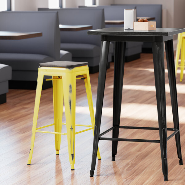 Lancaster Table & Seating Alloy Series Distressed Yellow Stackable Metal Indoor Industrial Barstool with Black Wood Seat