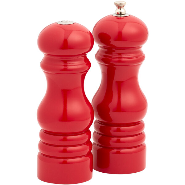 Two red American Metalcraft pepper mills with wooden tops.
