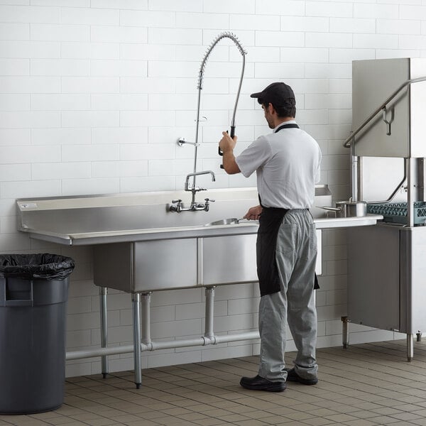 A man washing a Steelton 3 compartment sink.