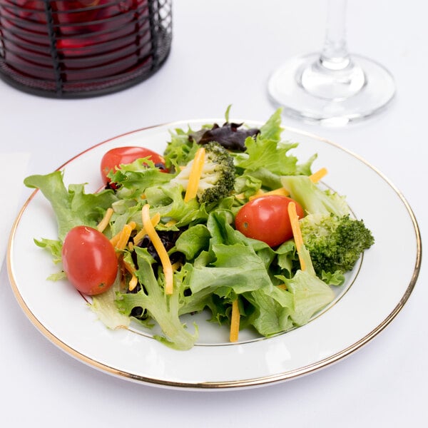 A CAC porcelain plate with broccoli, tomatoes, and cheese on a salad.