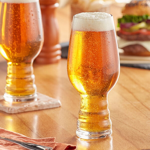 Two Acopa Select IPA beer glasses on a table with a burger.