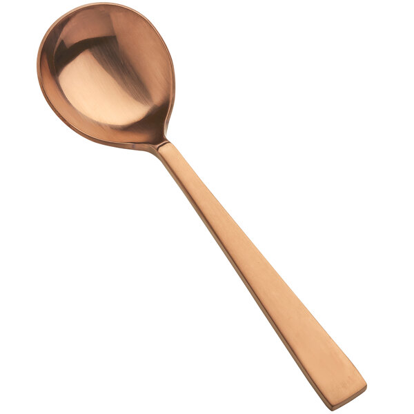 A close-up of a Bon Chef matte rose gold round bowl soup spoon with a handle.