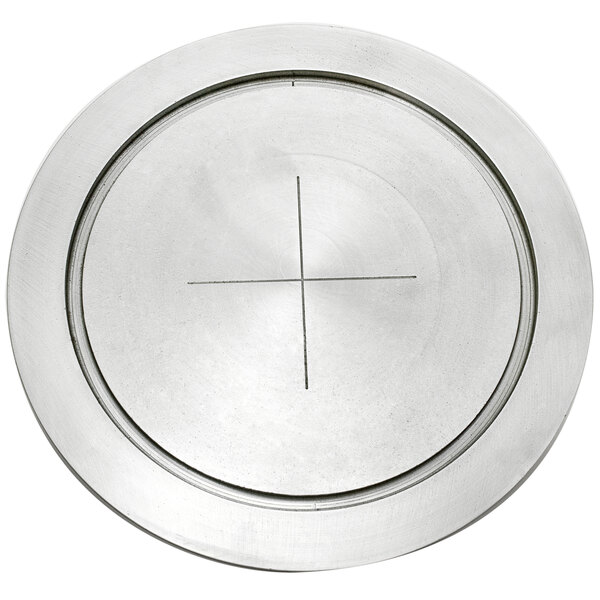 A silver round metal plate with a cross on it.