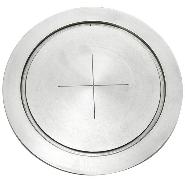 A circular silver metal plate with a cross on it.
