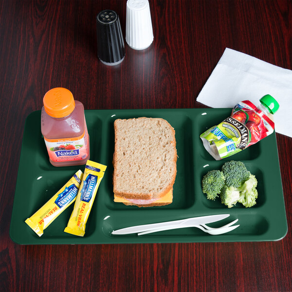 A Cambro Sherwood Green 6 compartment tray with a sandwich, fruit, and drink on it.