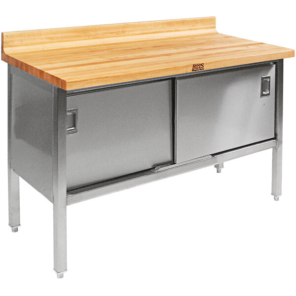 A John Boos wood top work table with stainless steel base and sliding doors.