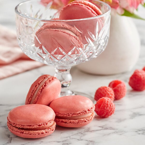 A glass bowl filled with White Toque French pink macarons.