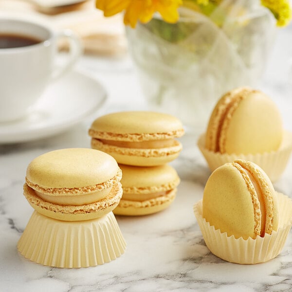 A group of White Toque French Lemon Macarons on a table.