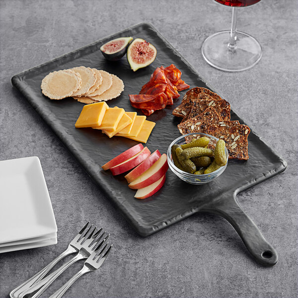 A Tablecraft rectangular faux slate melamine serving paddle with a plate of food and a glass of wine.