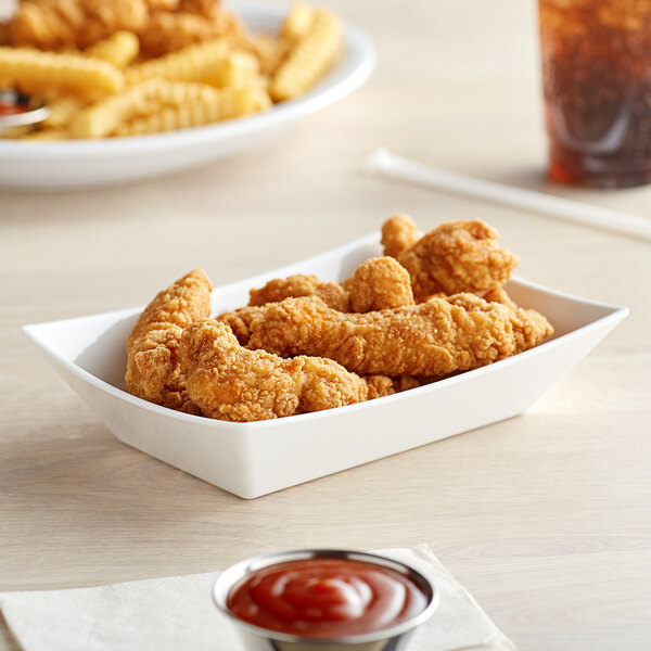 A white Tablecraft rectangular serving basket with fried chicken and french fries inside.