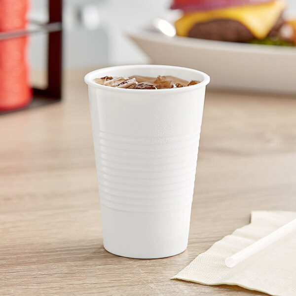 A Tablecraft white melamine tumbler with a drink and a straw.