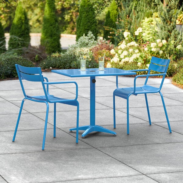 A blue table and two chairs on a patio.