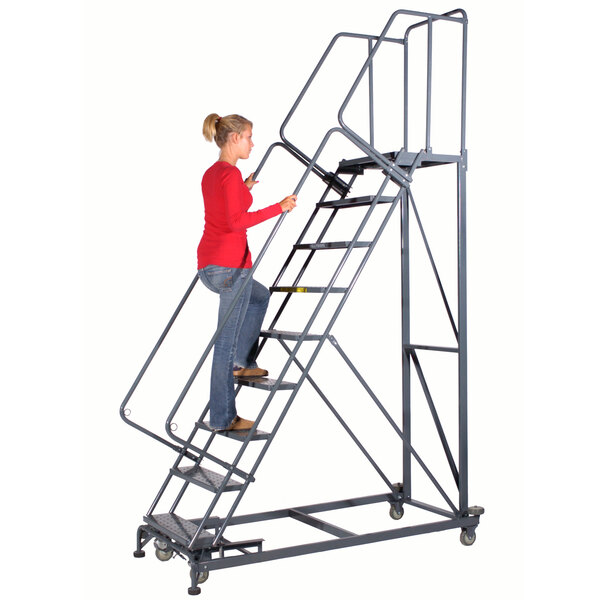A woman in a red shirt and blue jeans climbing a Ballymore steel rolling safety ladder.