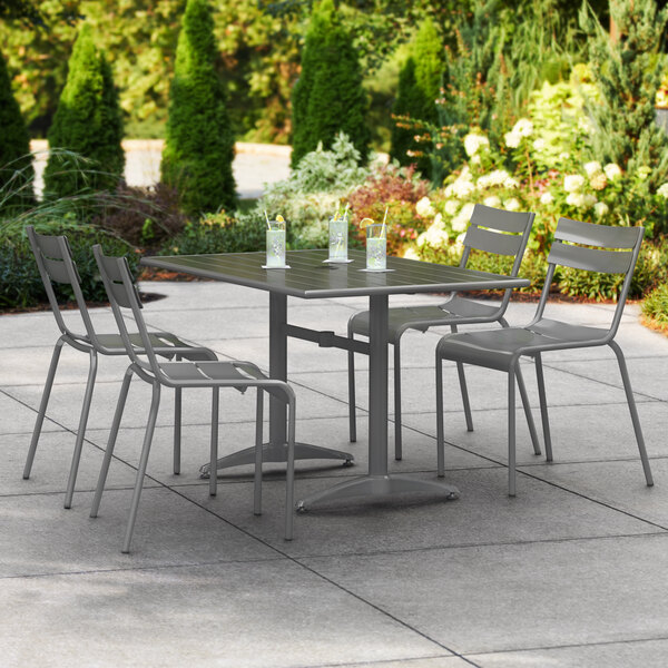 A Lancaster Table & Seating matte gray aluminum dining height table with chairs on an outdoor patio.