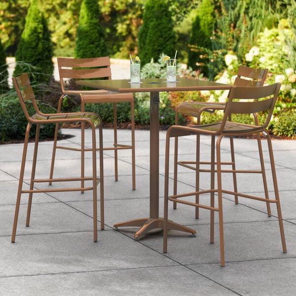 A Lancaster Table & Seating bar height table with chairs on a patio.