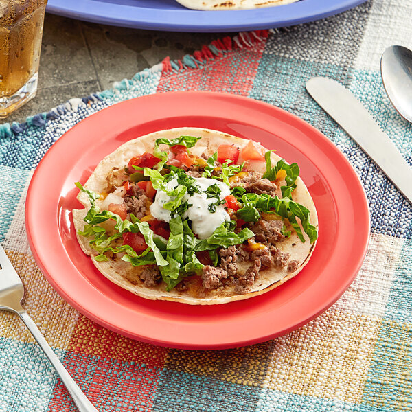 An Acopa orange melamine plate with a taco on it.
