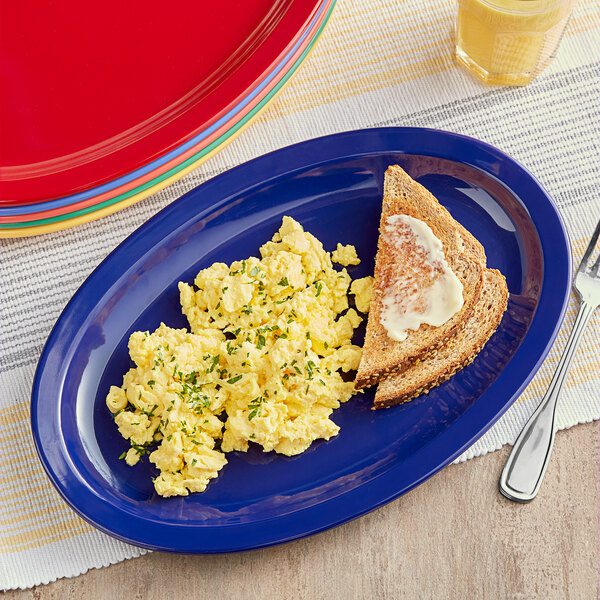 An Acopa Foundations narrow rim melamine oval platter with scrambled eggs and toast on it.
