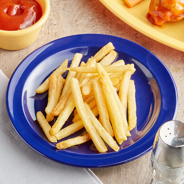 A plate of french fries with ketchup on an Acopa Foundations blue melamine plate.