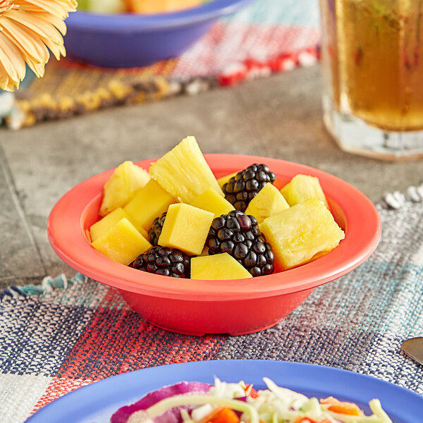 An Acopa orange melamine fruit dish filled with blackberries and pineapple.