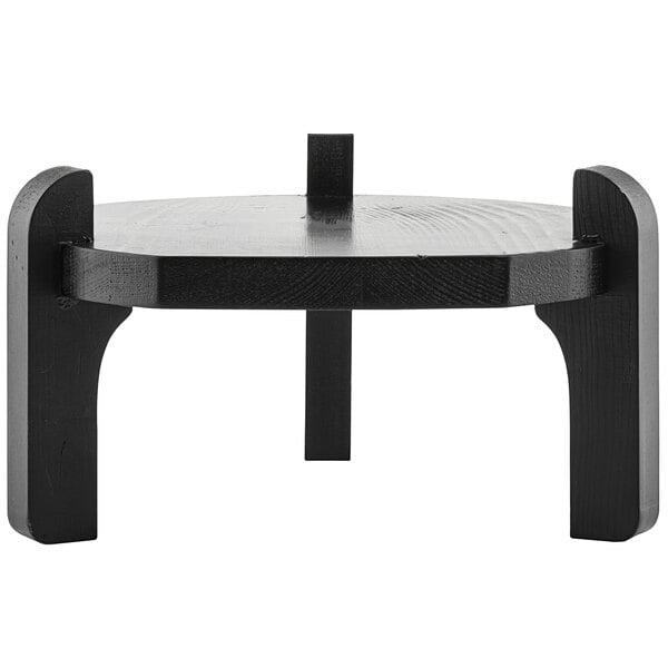 A black pinewood beverage dispenser stand on a round table.